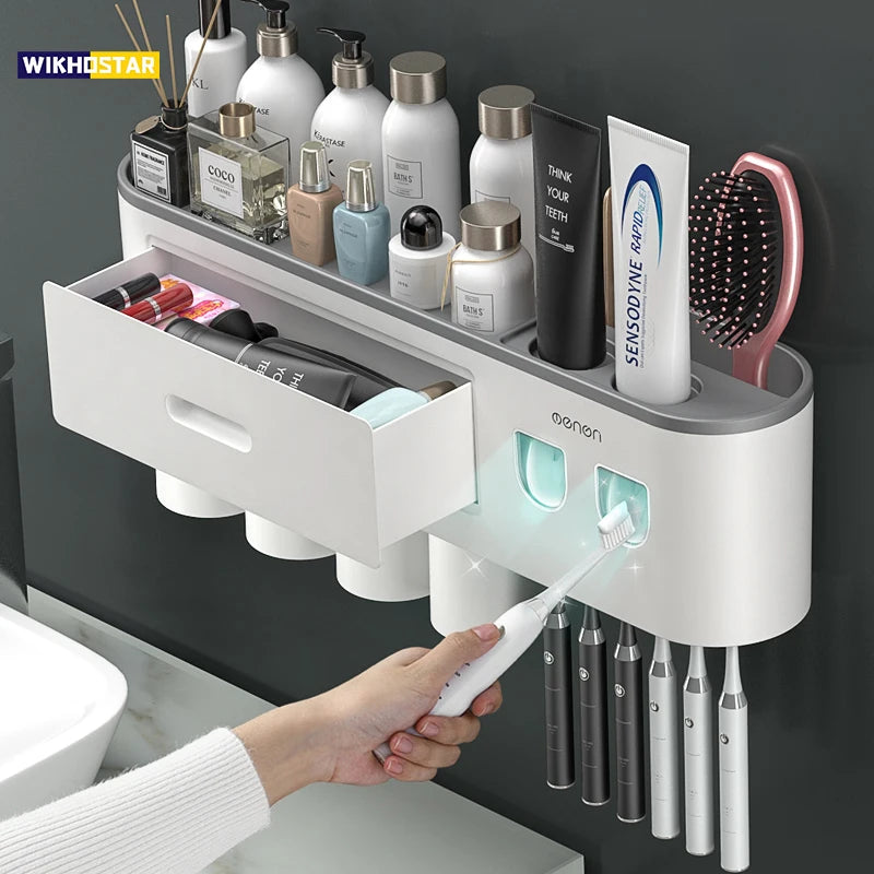 Wall-mounted bathroom organizer with toothbrush holder, toiletries, and a hand holding a toothbrush.

