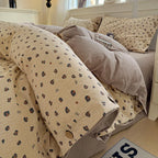 Beige and brown patterned comforter on a bed with pillows in a bedroom setting.

