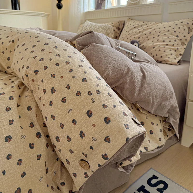 Beige and brown patterned comforter on a bed with pillows in a bedroom setting.

