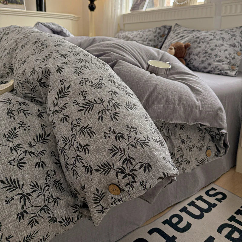 Bed with floral-patterned comforter and pillows in a bedroom setting.

