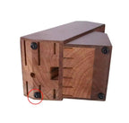 A reddish-brown wooden block or bracket with pre-drilled slots and four black screws, shown on a plain white background with one screw circled in red.

