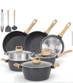 A 7-piece non-stick cookware set with dark gray speckled interiors and light wood handles, shown with three lids and three utensils (tongs, spatula, and ladle) on a white background.

