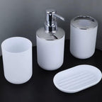 Three-piece white bathroom vanity set with chrome details, including a toothbrush holder, a soap dispenser, a cup, and an oval soap dish, shown on a dark background.

