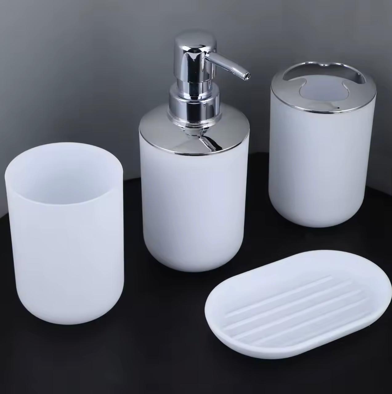 Three-piece white bathroom vanity set with chrome details, including a toothbrush holder, a soap dispenser, a cup, and an oval soap dish, shown on a dark background.

