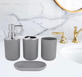 Gray bathroom vanity set including a soap dispenser, cup, tumbler, and soap dish, shown on a white marble countertop with a gold faucet.

