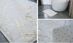 A collage showing a white bath mat with a gold marble pattern. The left panel shows a close-up of the textured surface with gold veins.

