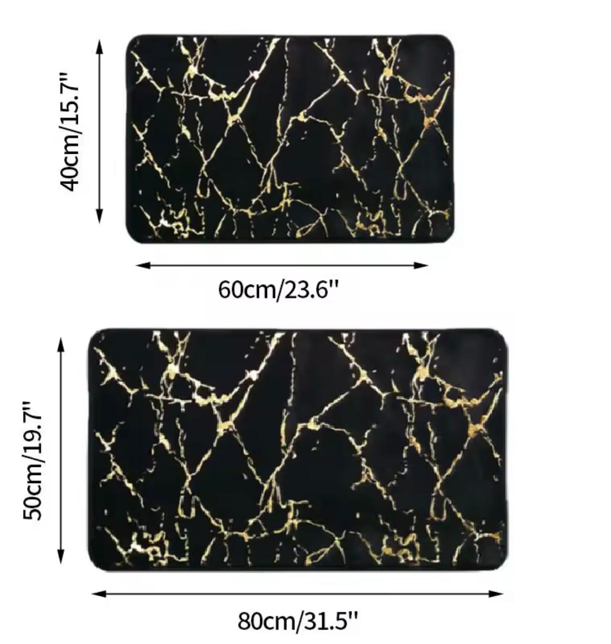 Two rectangular black mats with a gold marble vein pattern, shown with dimension labels indicating 60cm by 40cm and 80cm by 50cm sizes on a white background.


