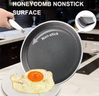 A hand holds a nonstick frying pan over a plate with a fried egg in a kitchen setting. Large text reads 'HONEYCOMB NONSTICK SURFACE,' and a circular inset shows the pan's textured nonstick coating.

