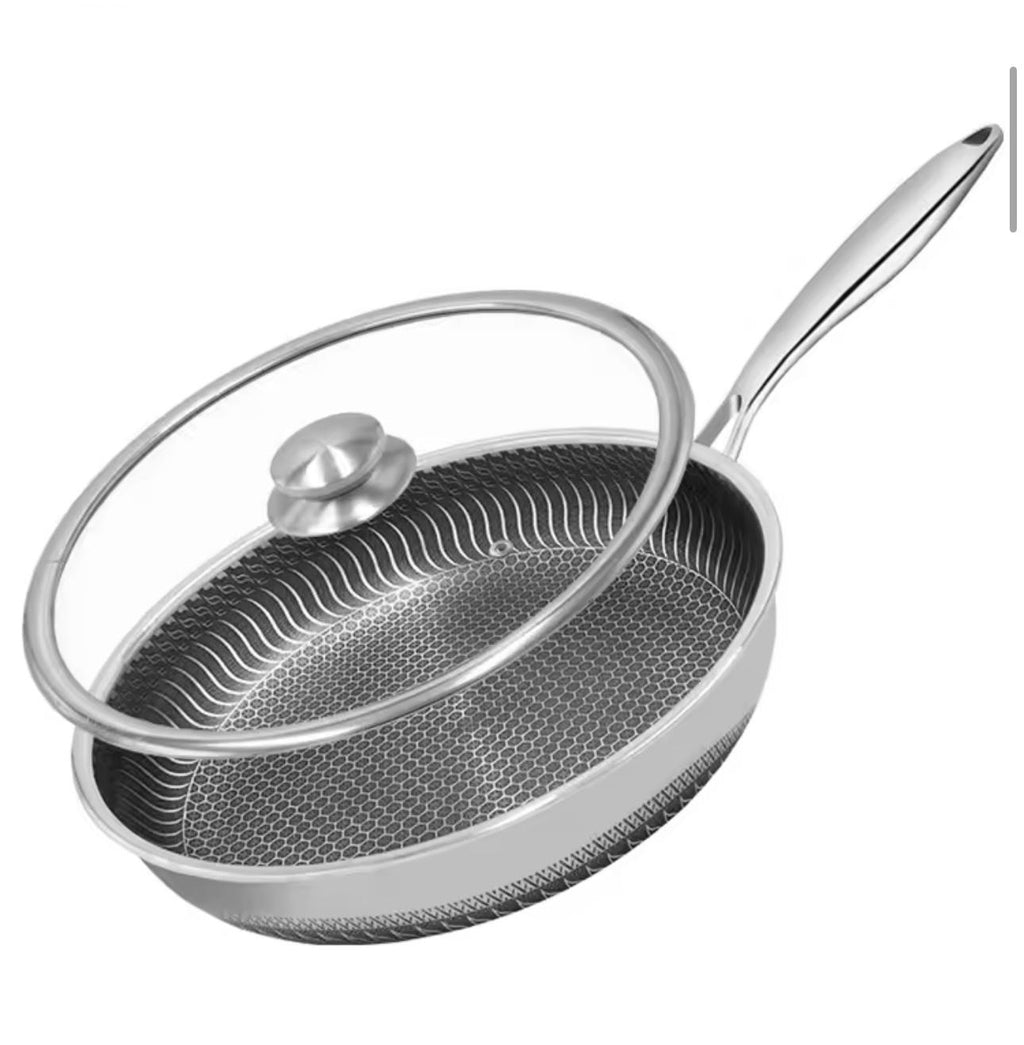 A stainless steel sauté pan with a textured non-stick interior and a clear glass lid featuring a silver knob and rim, shown on a plain white background.

