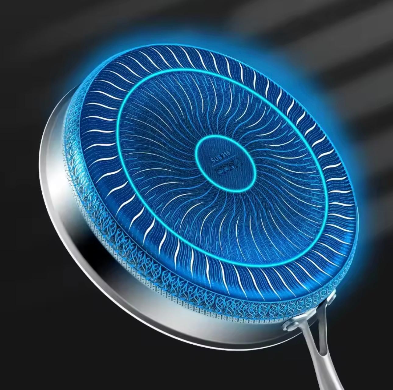 A close-up of a frying pan underside with a metallic silver rim and a bright blue glowing non-stick coating pattern, shown on a dark background.

